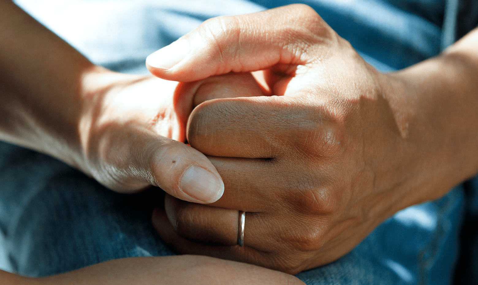 Dieses Bild zeigt zwei Hände, die sich halten als Symbolbild für Sturzprävention in der Pflege