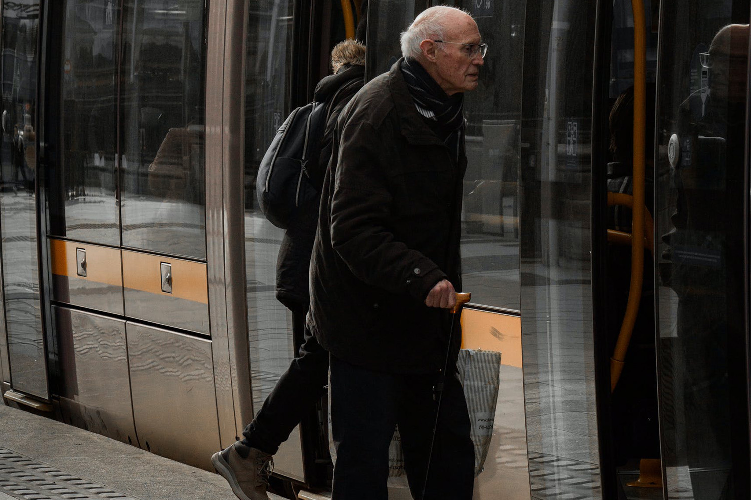 Dieses Bild zeigt einen Senior mit Gehstock vor einer S-Bahn