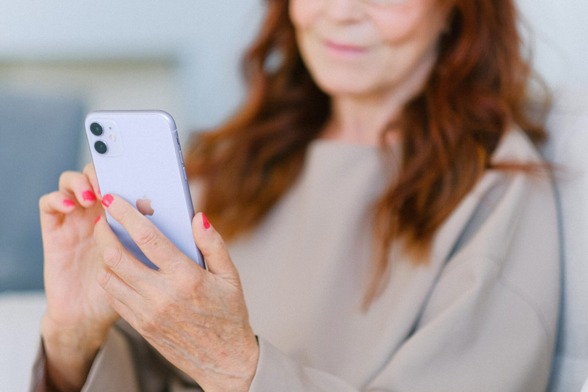 Dieses Bild zeigt eine Frau mit Handy, die auf ein E-Rezept guckt